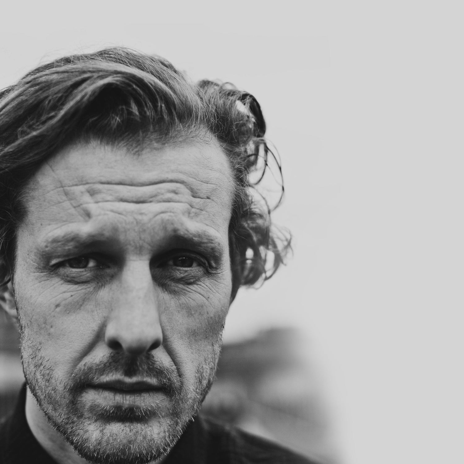 Black and white portrait of a man with a serious expression.